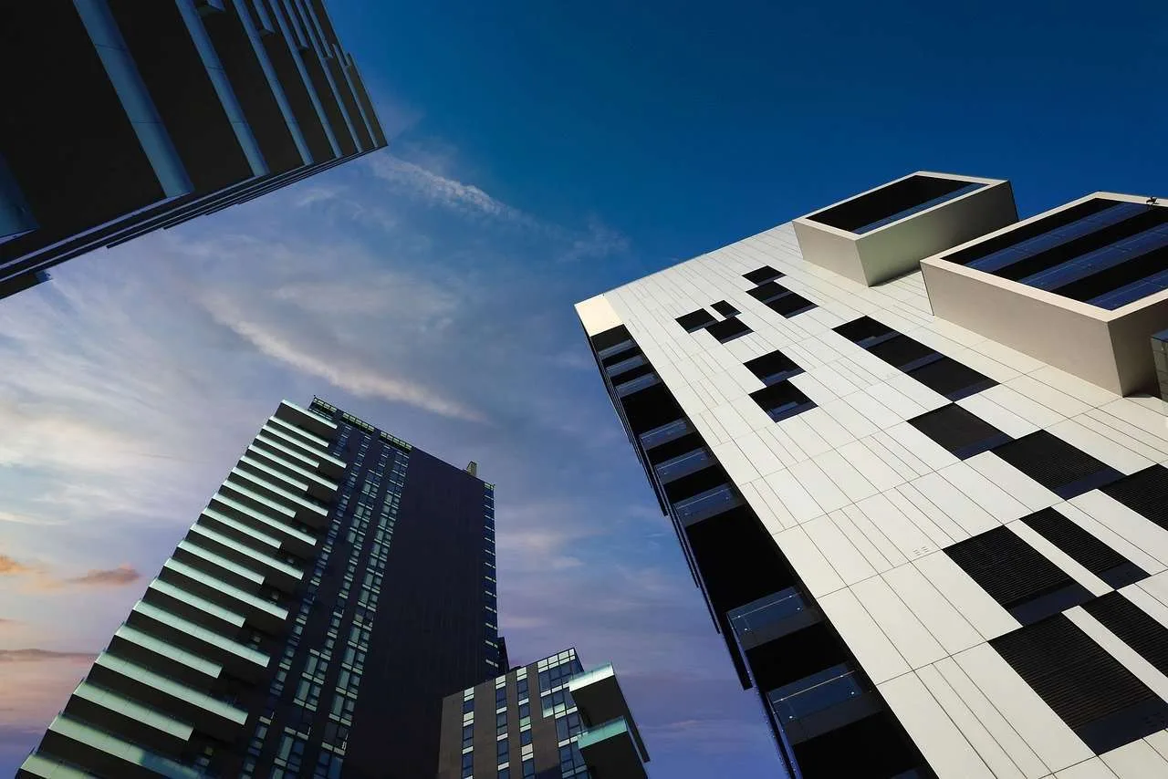 Commercial real estate buildings overshadowed by the symbol of high interest rates.